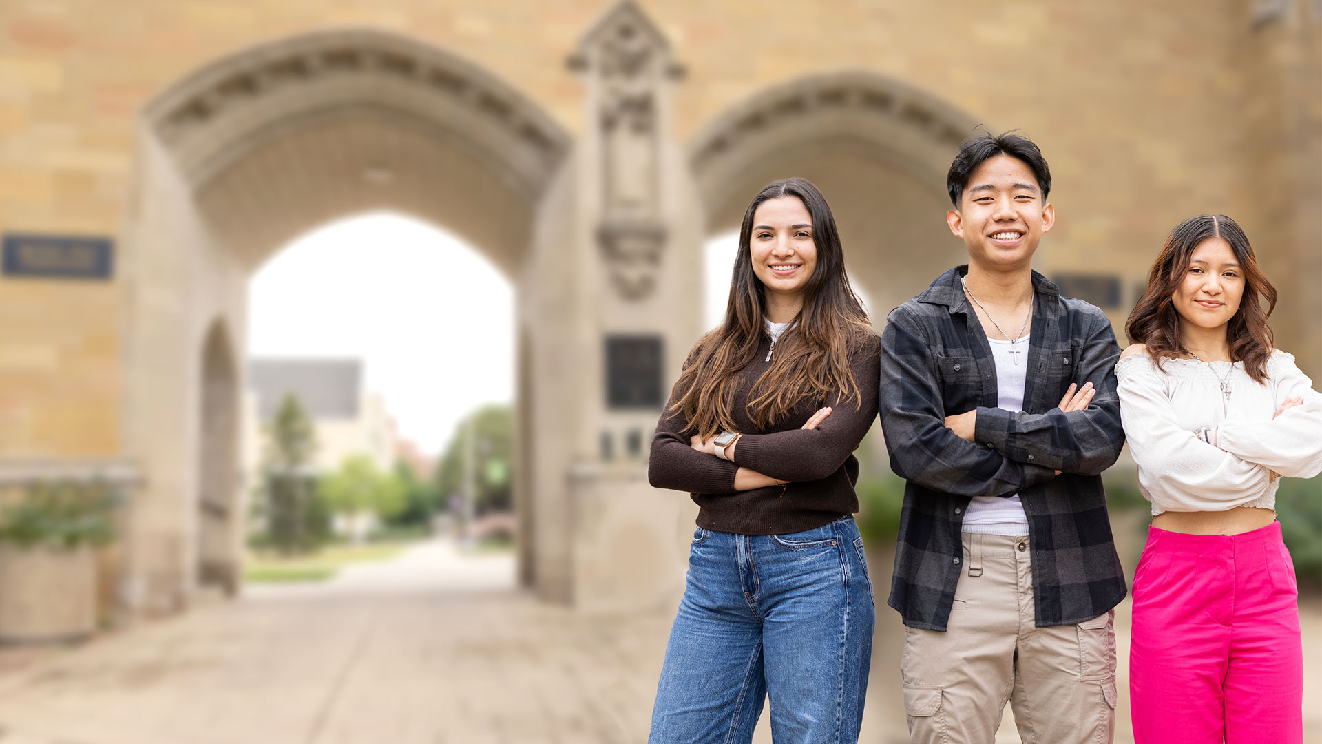 three friends smiling in front of the arches
