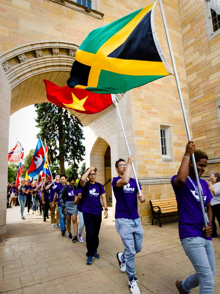 International students carry their country flags during March through the Arches