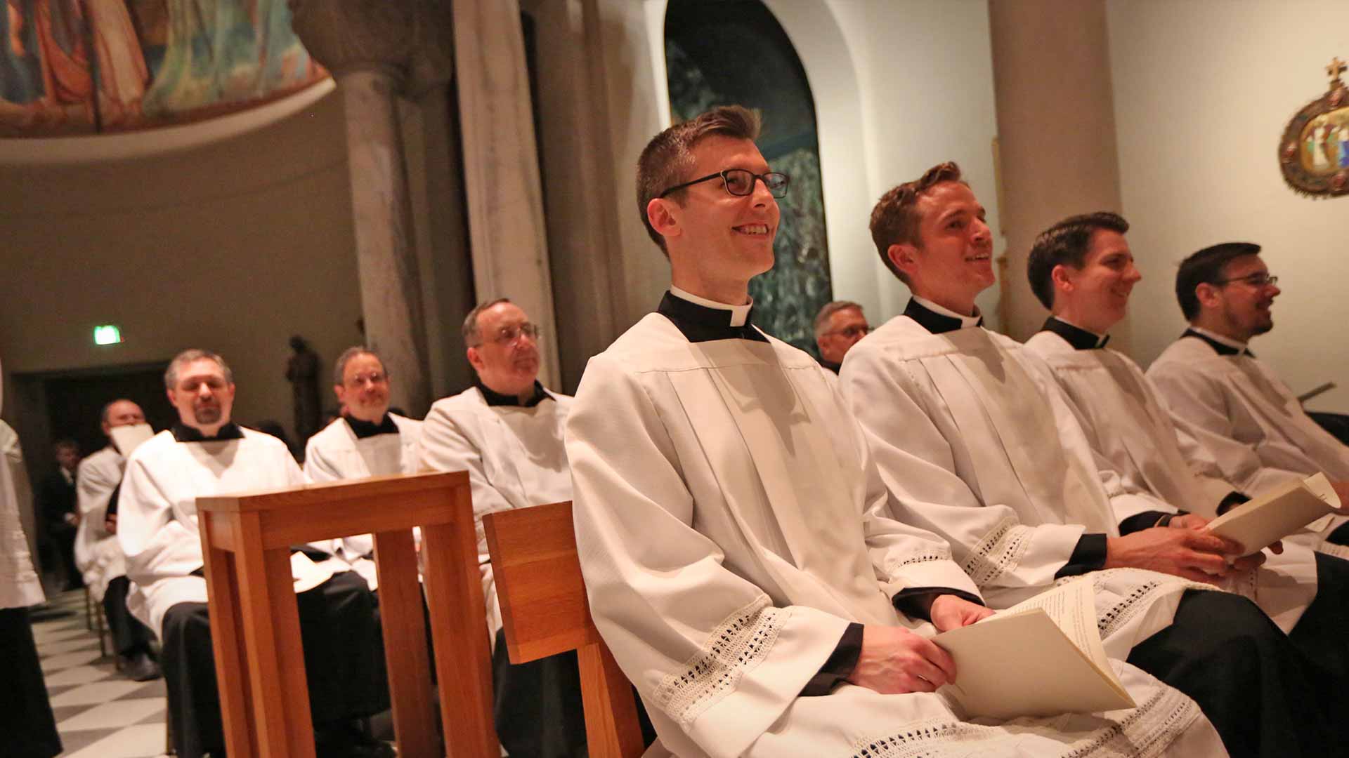 Seminarians sitting and smiling in Chapel