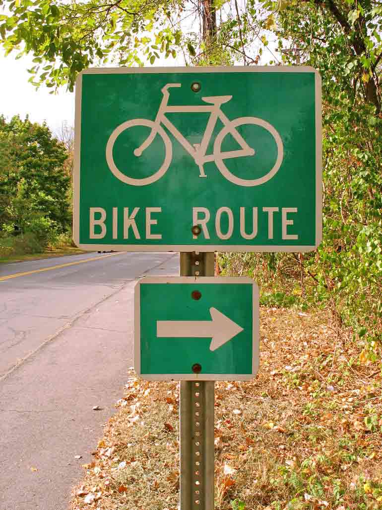 A road sign displaying direction of a bike trail.