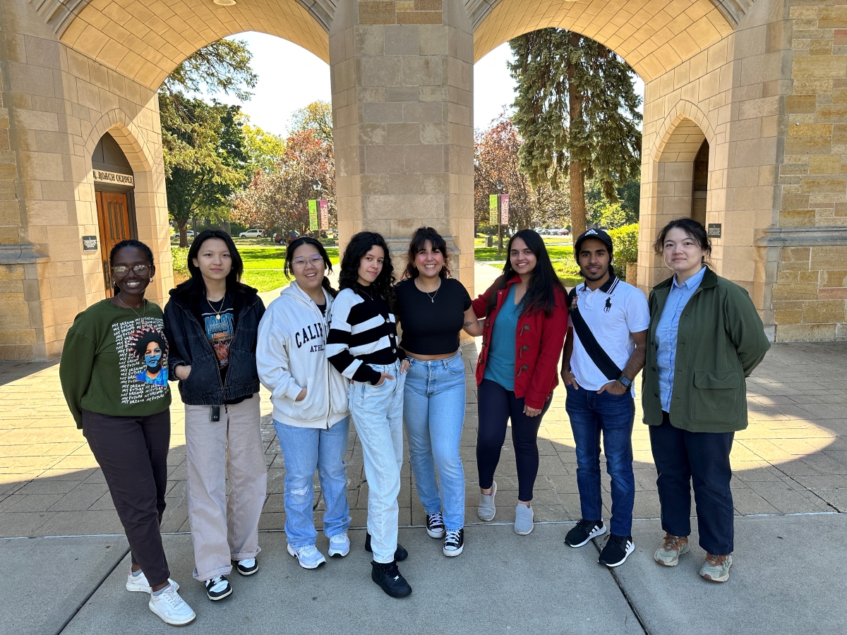 Students posing in front of the arches