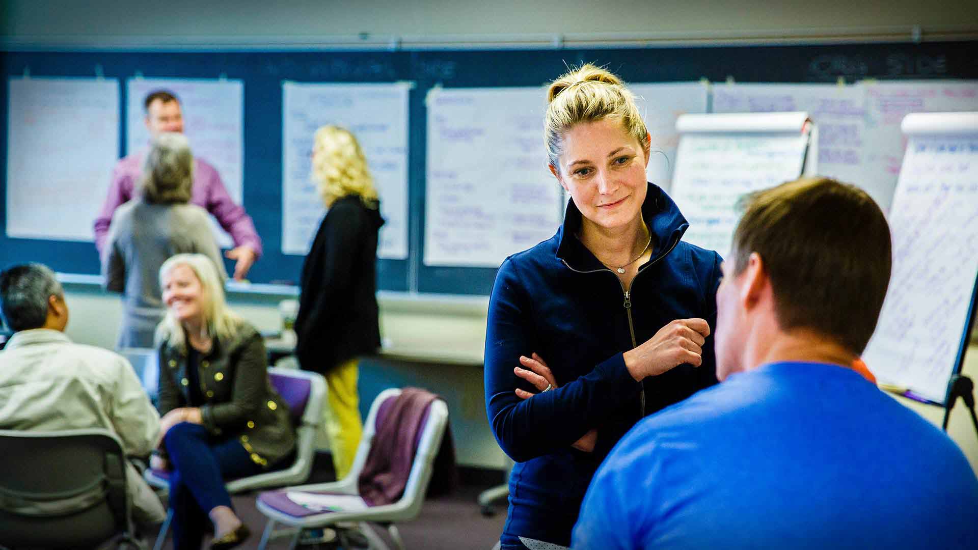 Two individuals talking in a classroom.
