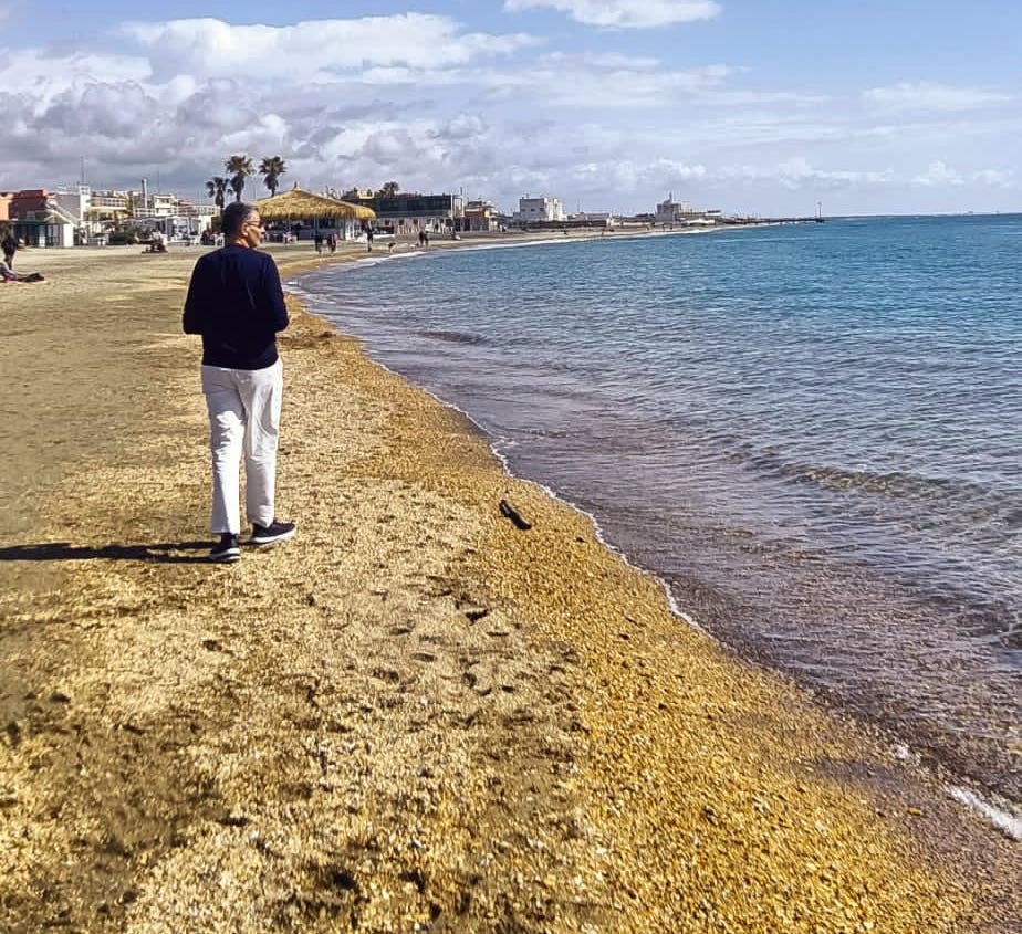 Man walking along the Italian beach shore