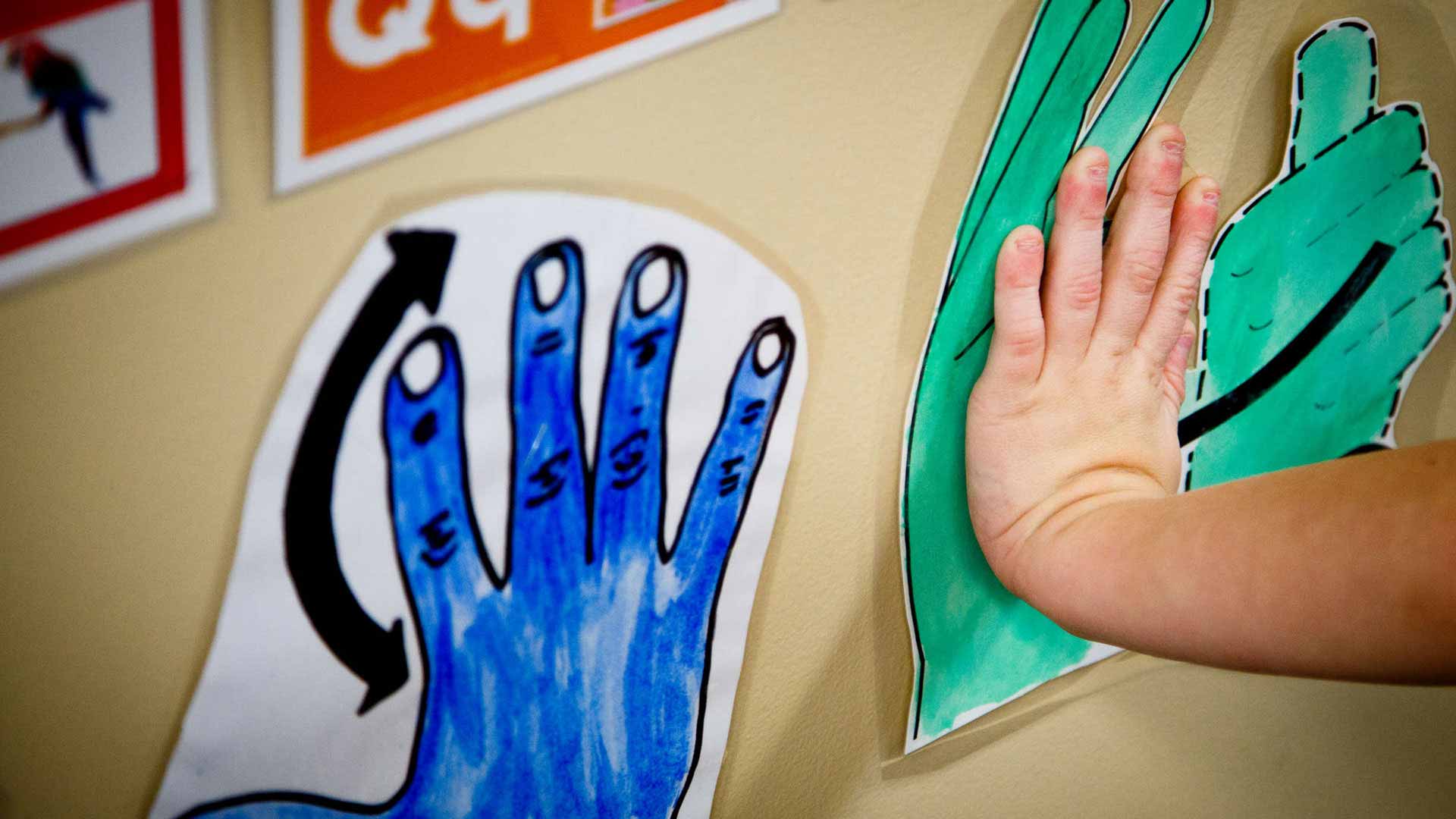 Child hand on wall art.