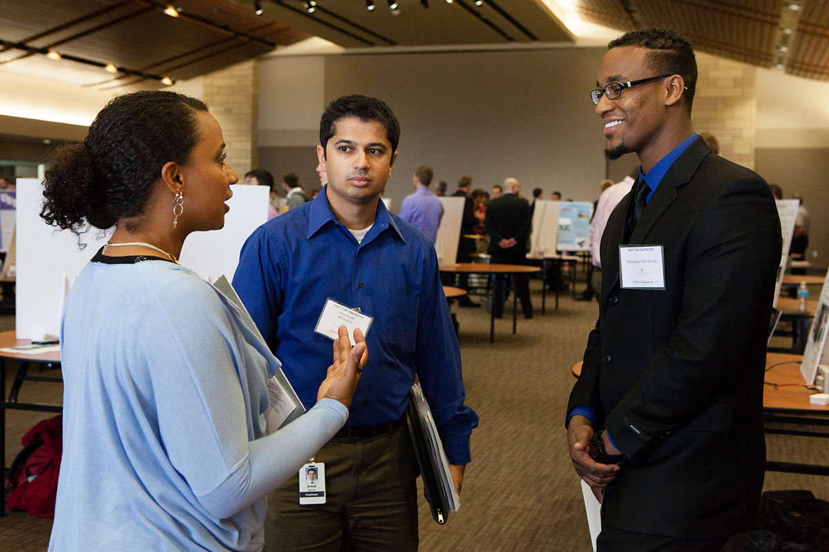 Students and potential employers converse during a career fair.
