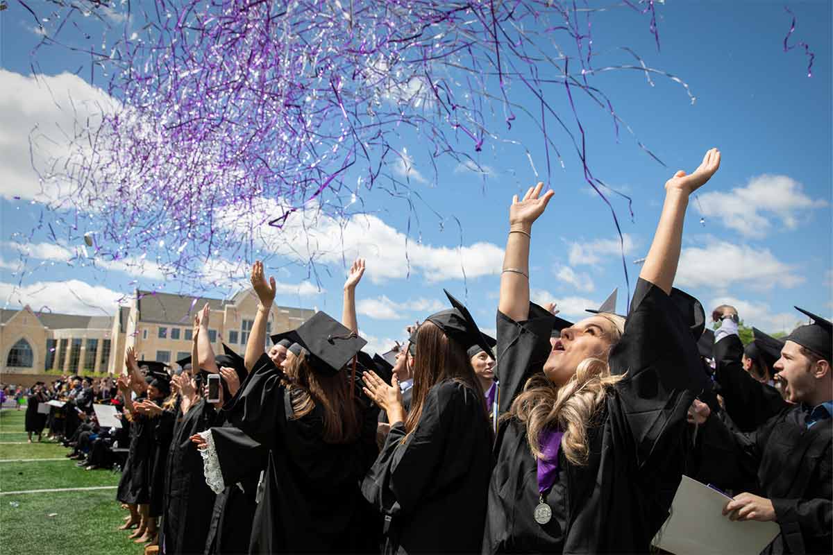 Students celebrating at graduation with confetti 