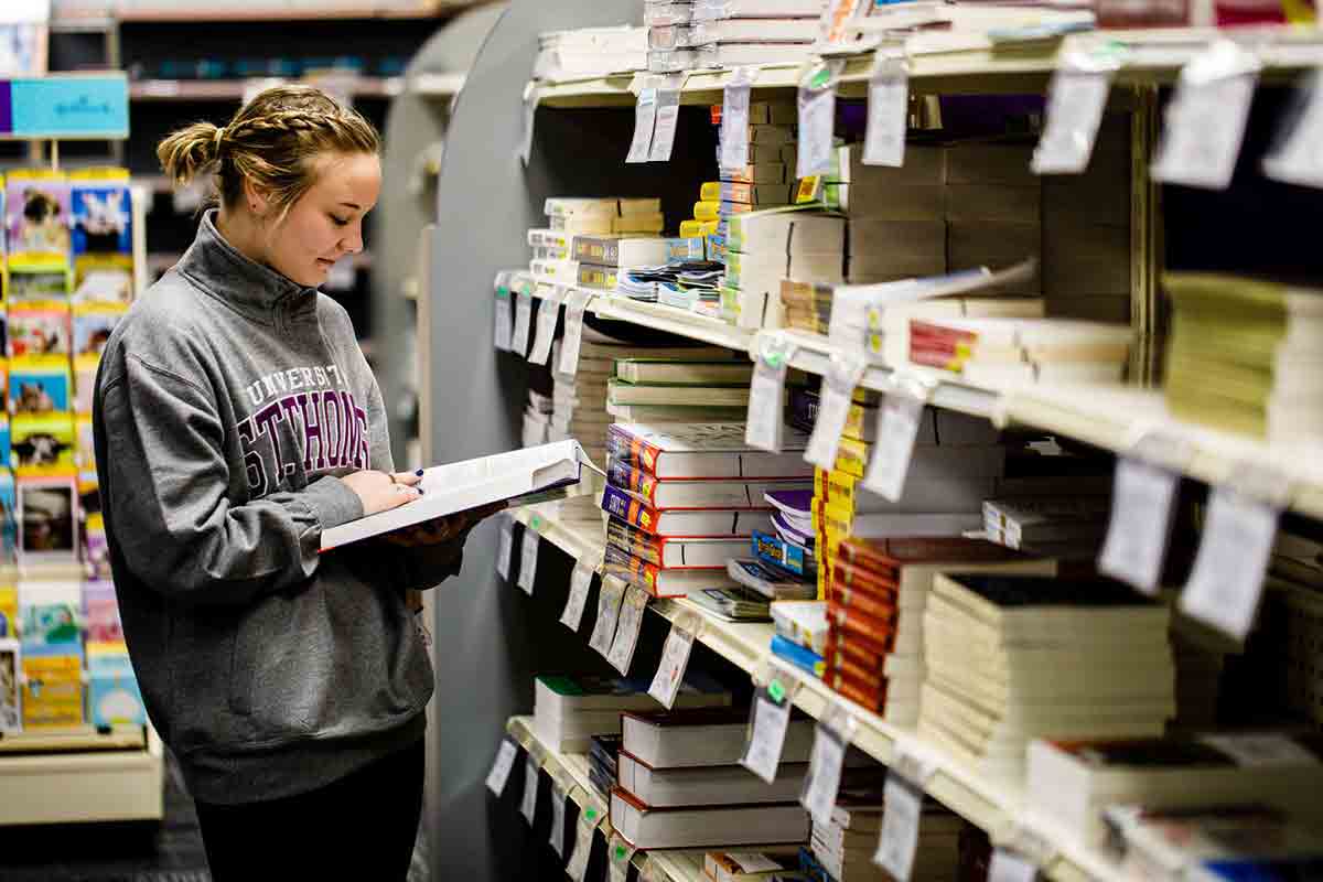 A book store student employee reads in the St. Thomas bookstore.
