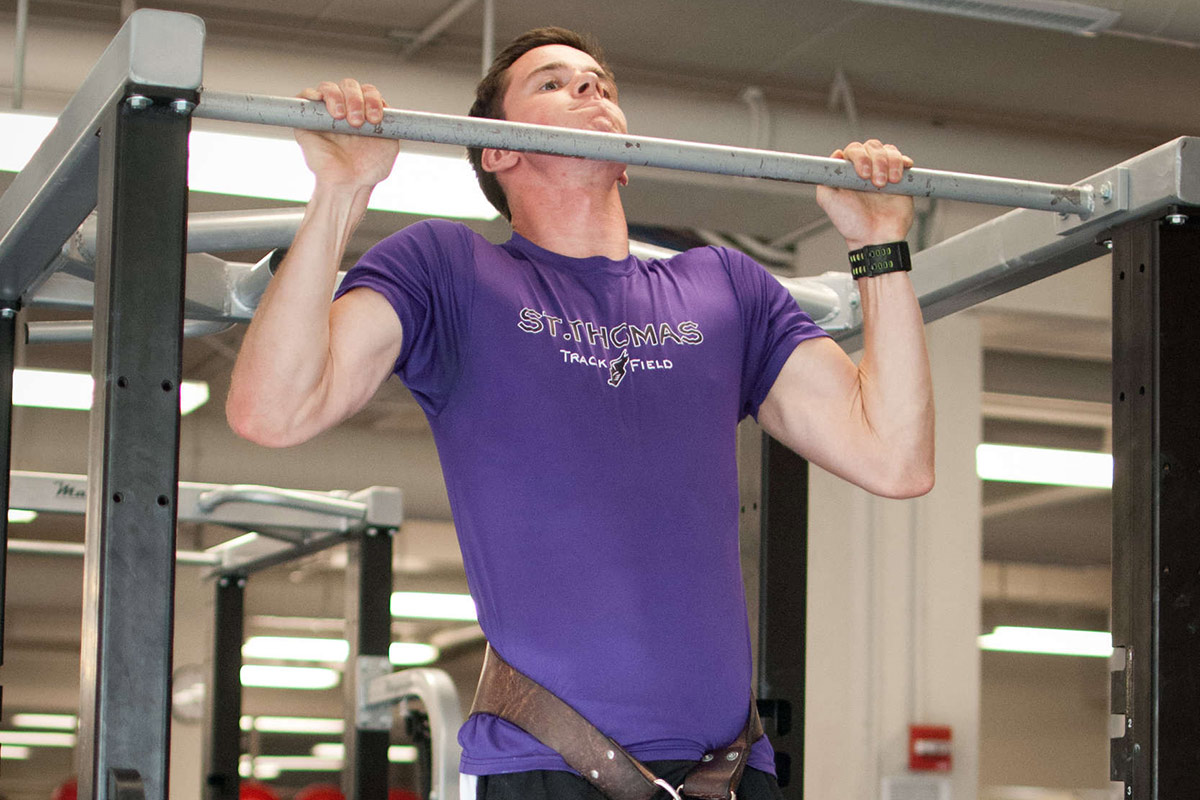 A University of St. Thomas student works out in the weight room.