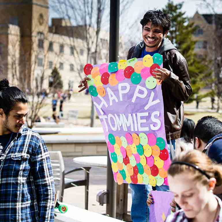 Students from the ""Happy Tommies"" group hold a sign