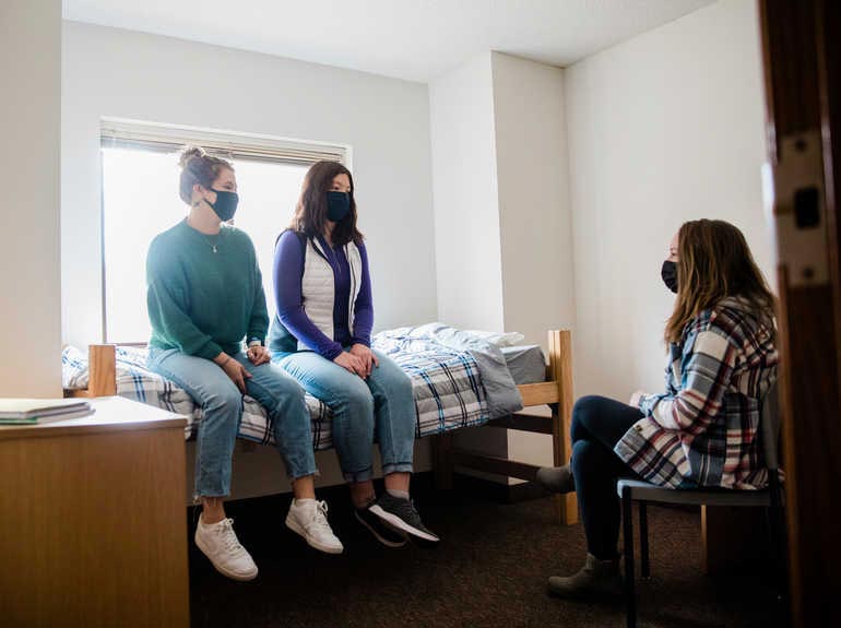 students sitting on a bed in a room