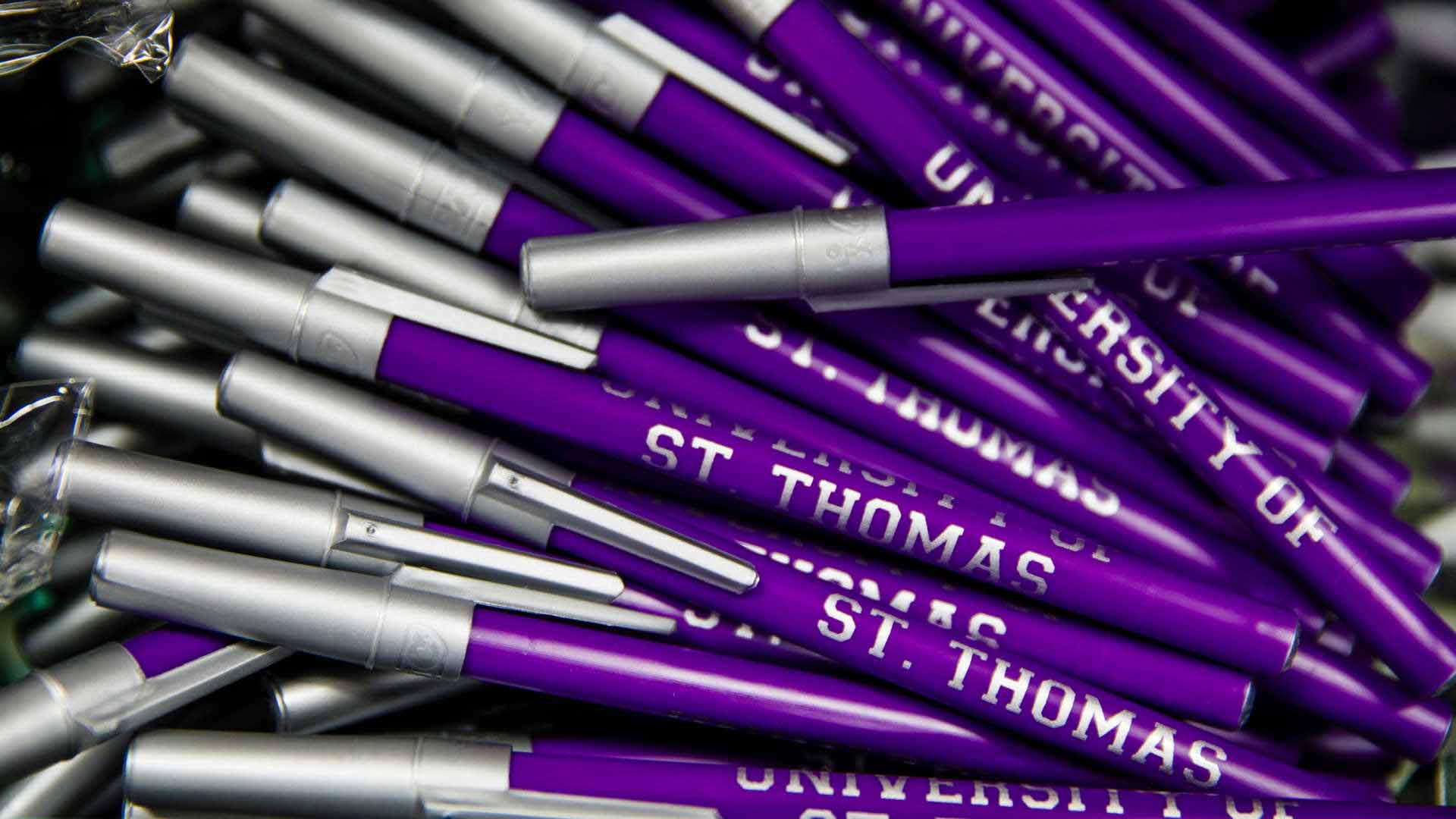 purple colored pens that say University of St. Thomas