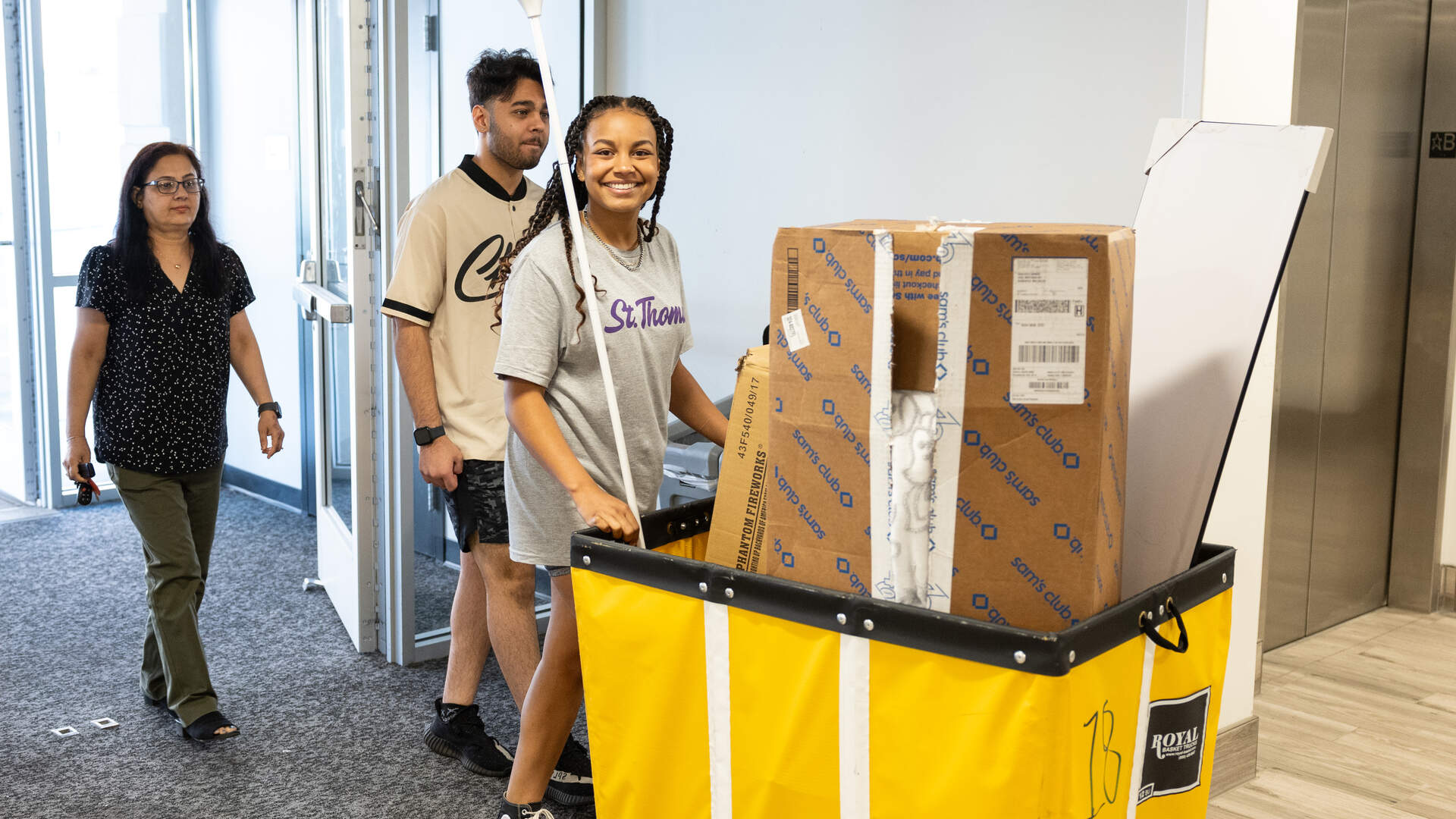 students smile while moving into residence halls