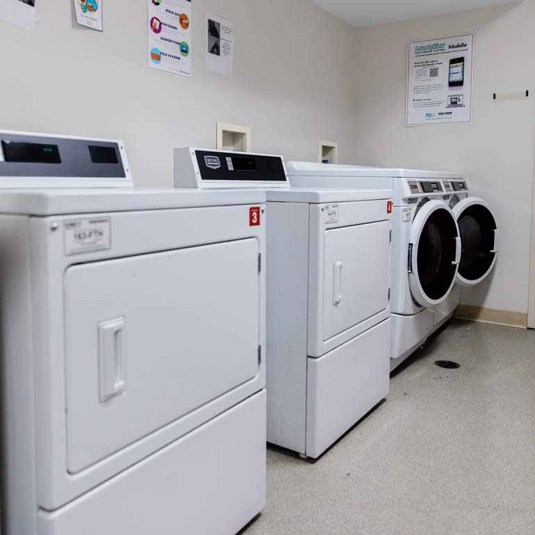 Laundry room with two washers and two dryers.