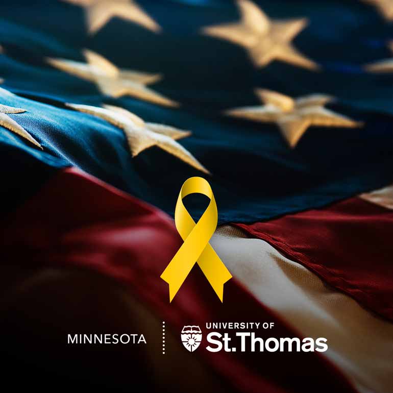 A yellow ribbon lies in front of the American Flag and the St. Thomas logo is at the bottom.