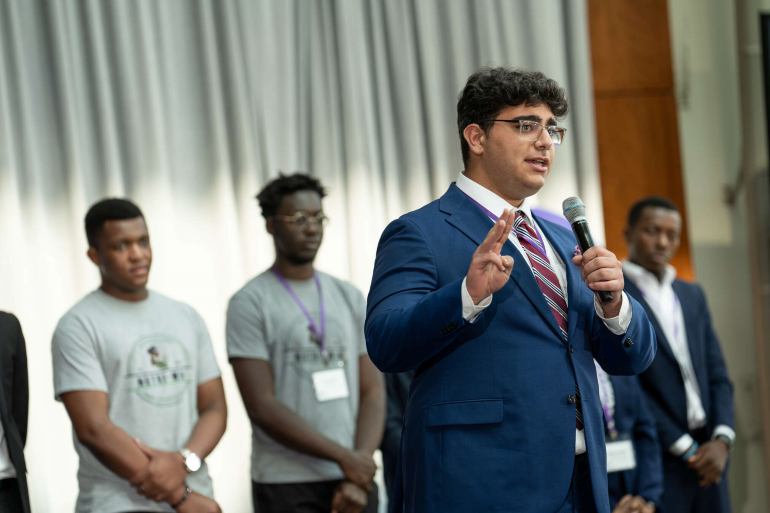 Student in suit speaking into a microphone