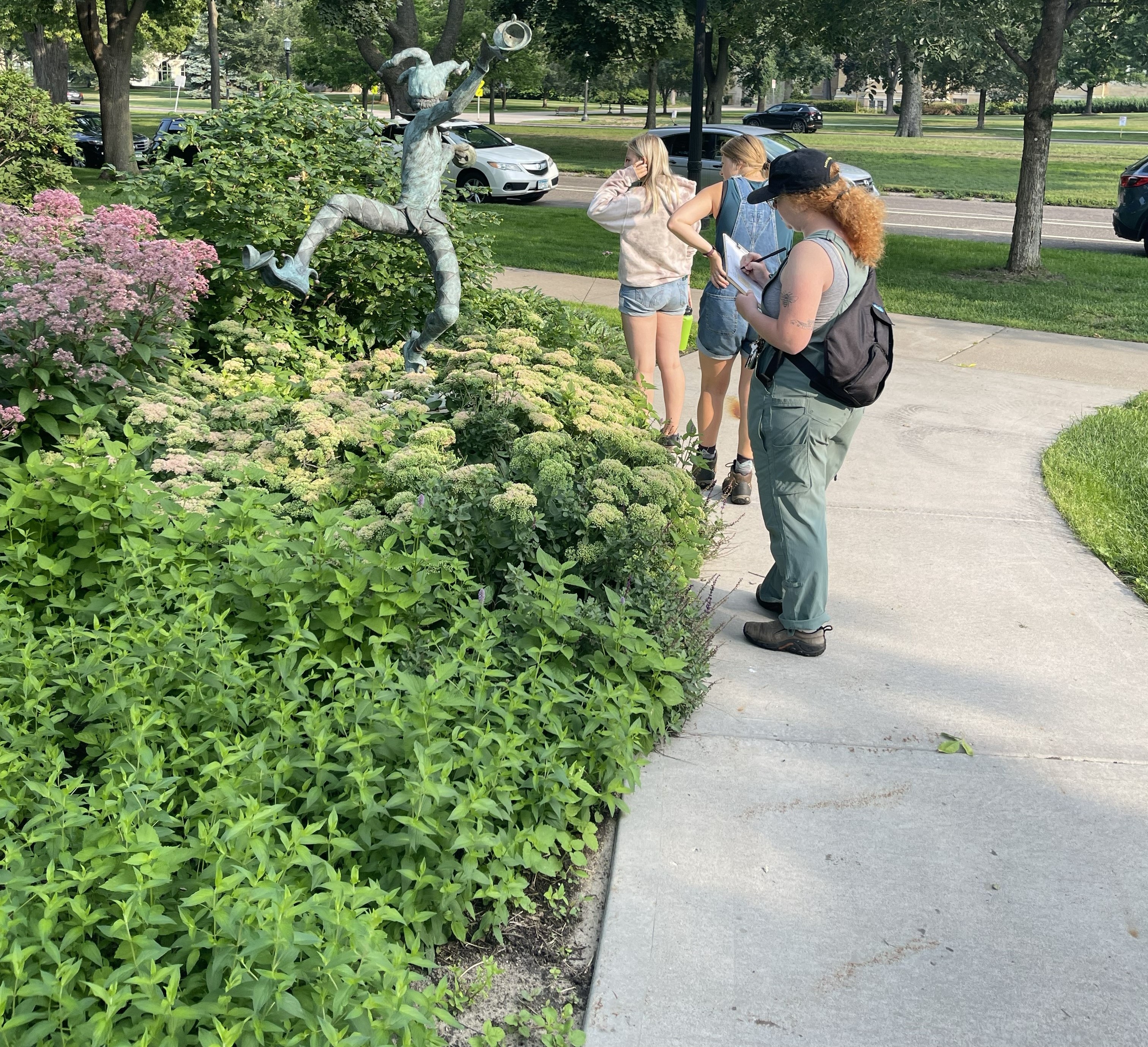 student researchers looking at flowers in the pollinator garden