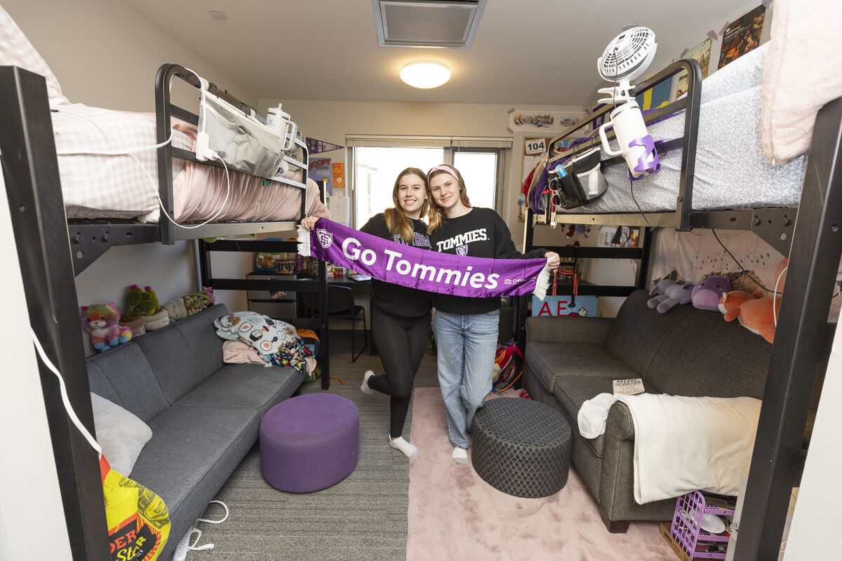 Students hold a scarf that says Go Tommies