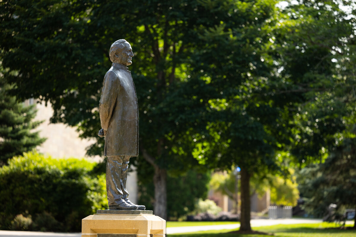 John Ireland statue with green trees behind it