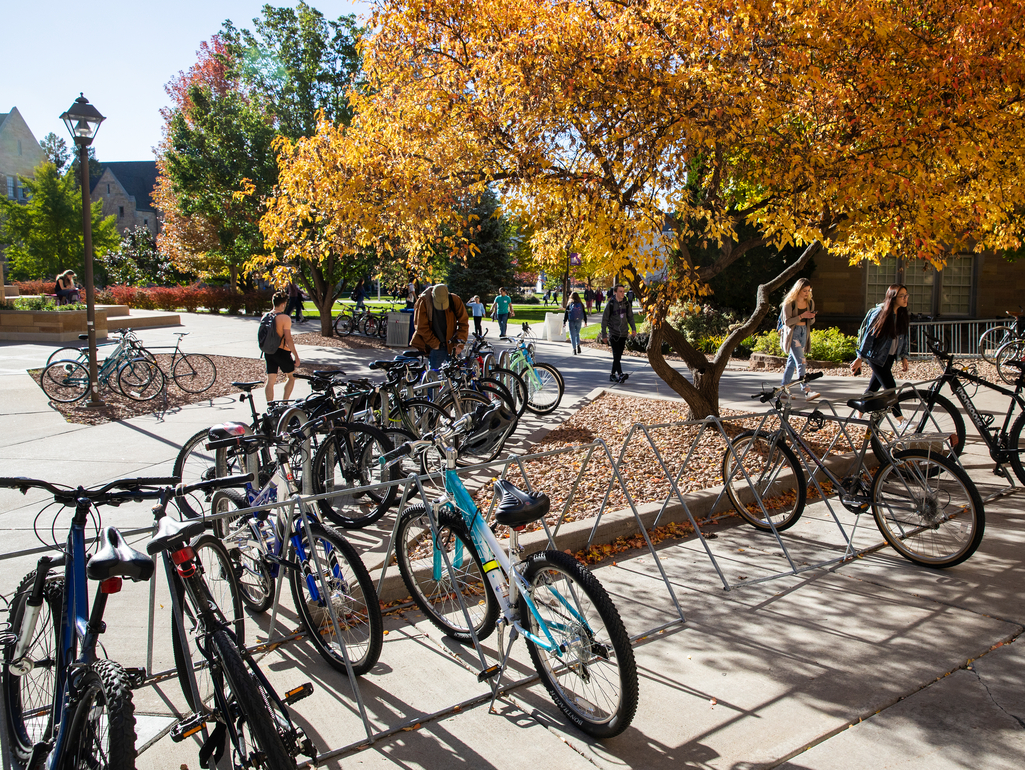 students walk near a bicycle rack