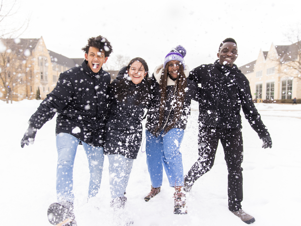 arm-in-arm students kick up snow