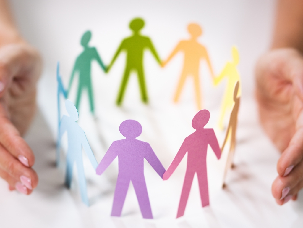 Colorful paper cut-outs of people holding hands